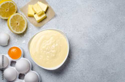 Basic french sauce hollandaise in a white bowl with ingredients,
