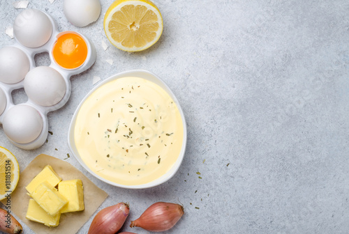 Basic french sauce bearnaise in a white bowl with ingredients, b photo