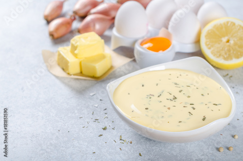 Basic french sauce bearnaise in a white bowl with ingredients, b