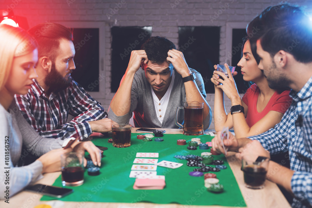© VadimGuzhva - Young people play poker at the table.