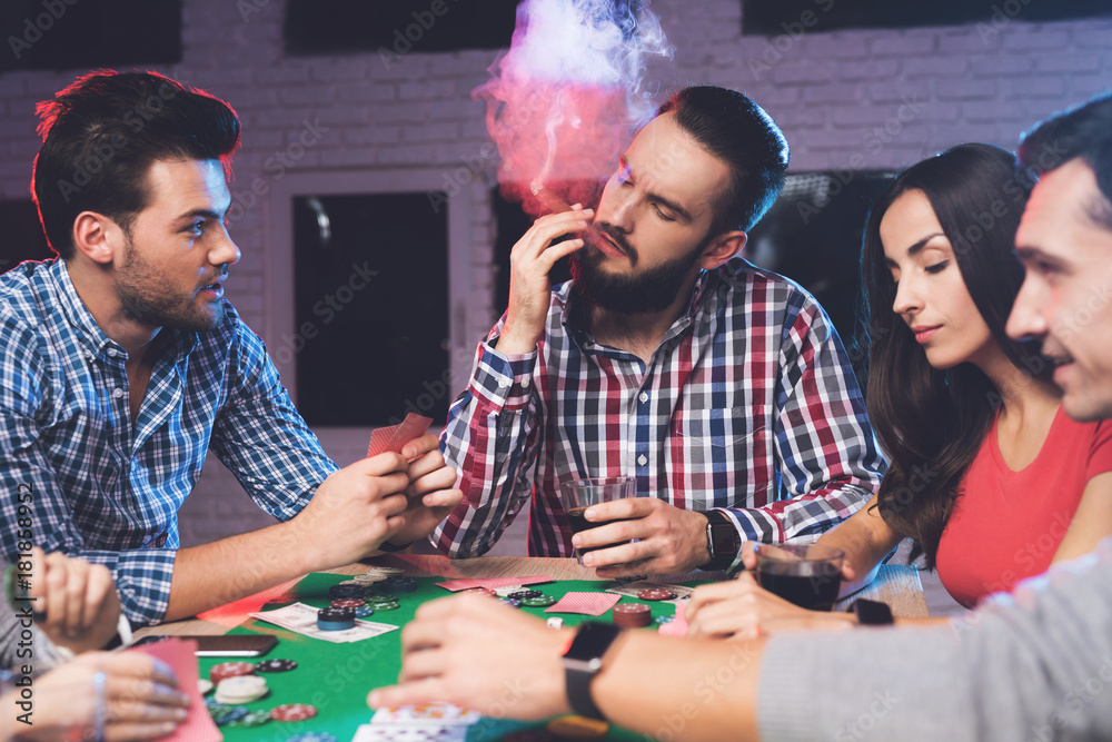 Young people play poker at the table. Young people play poker at the table.