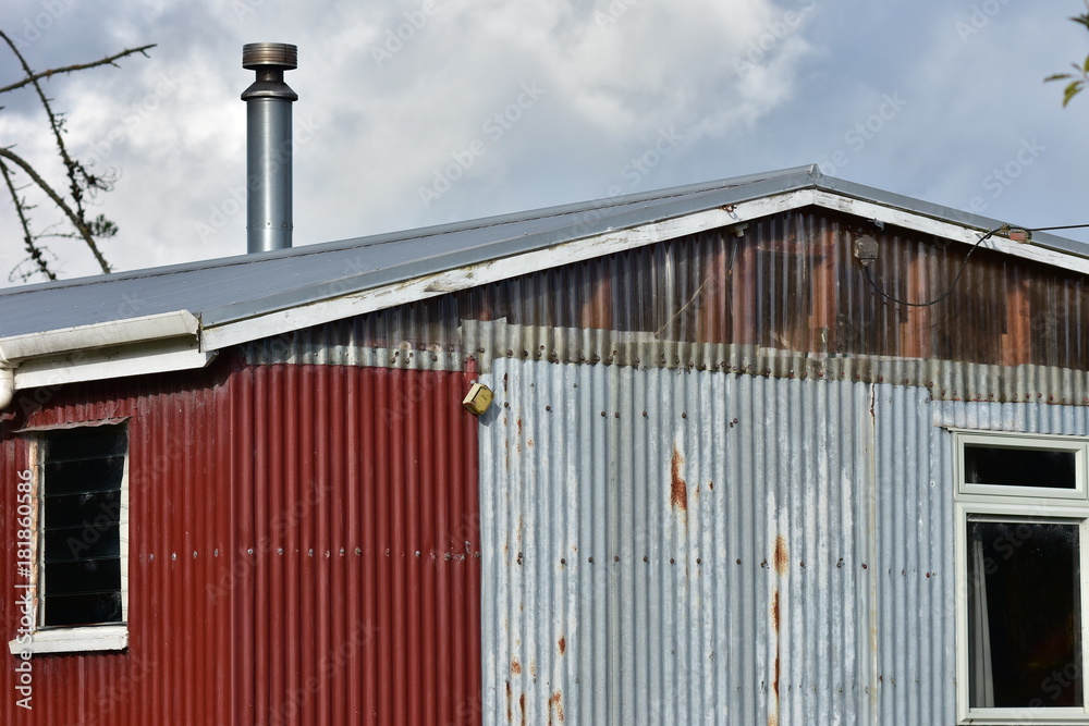Shed made from partially rusty corrugated sheet metal panels. Shed made from partially rusty corrugated sheet metal panels.