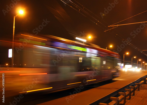The motion of a blurred trolleybus in the street in the evening