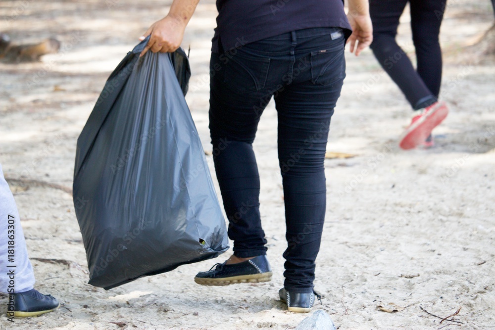 People is caring about environmental at the beach by picking up trash People is caring about environmental at the beach by picking up trash