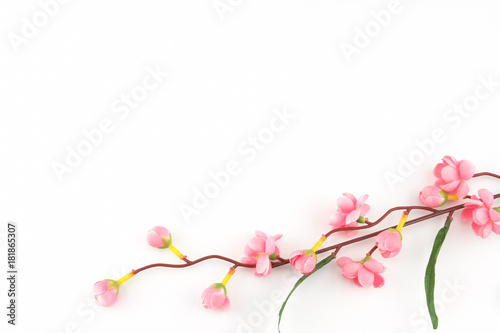 Fake pink flower branches on white background with copy space
