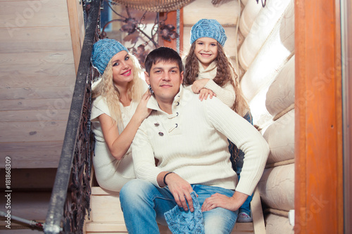 happy family mother, father, child daughter at home, in a winter sweater and hat, the concept of Christmas. on the stairs © satyrenko