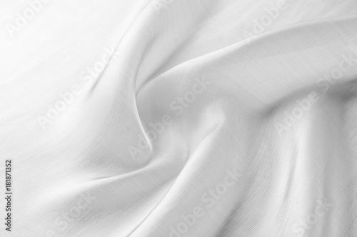 Background texture, pattern. The fabric is white. White silk fabric background elegant and delicate. Bright satin fabric, folded for use as a background. Upper type of fabric Textile surface.