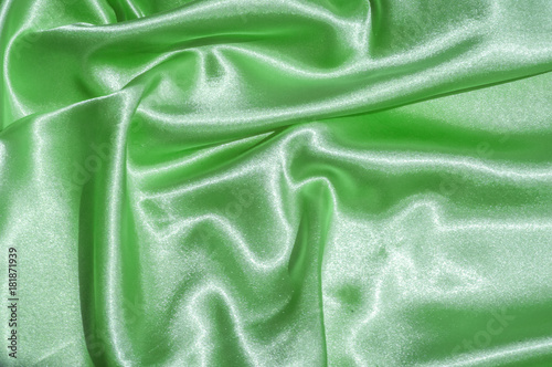 Texture, fabric, background. Abstract background of luxurious fabric or liquid waves or wavy grunge crease silk satin texture of velvet material or luxurious Christmas or elegant background. green