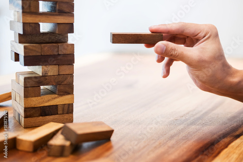 Fototapeta Naklejka Na Ścianę i Meble -  Business man placing wooden block on a tower concept of risk control planning risk and strategy.