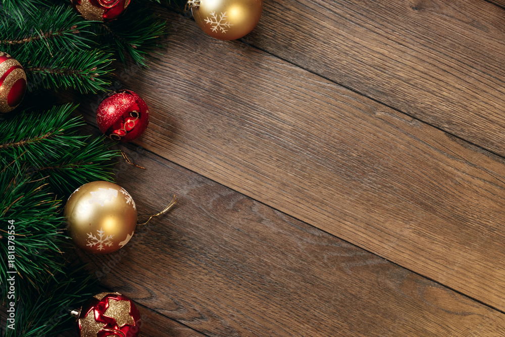 Christmas ornaments and pine branches on a wooden table. Holidays christmas background. Copy space for text or design. View from above. Christmas ornaments and pine branches on a wooden table. Holidays christmas background. Copy space for text or design. View from above.