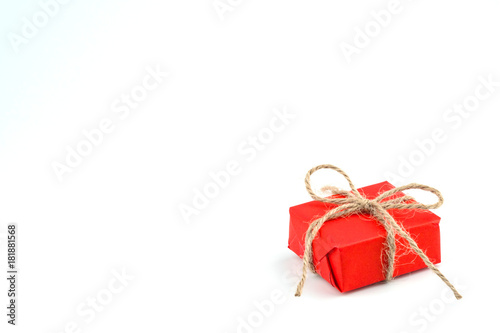 Red craft paper gift box tied with brown rope bow ribbon isolated on white background for Christmas, New Year and Valentine Day.