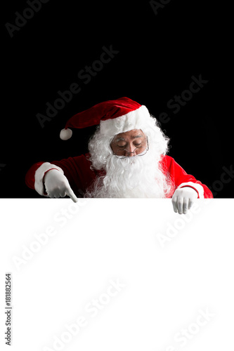 Santa Claus holding a white blank sign isolated on black  background © Johnstocker