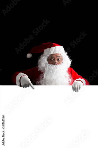 Santa Claus holding a white blank sign isolated on black  background © Johnstocker