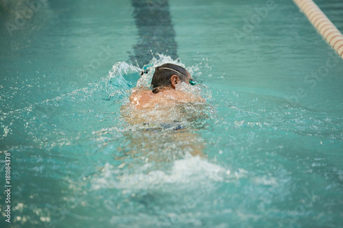 Senior man swimming in freestyle - Concept of sport and fun in swimming pool