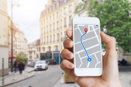 Tourist using GPS map navigation app on smartphone screen, direction