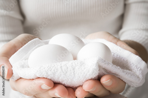 White eggs in the towel and woman's hands. Food concept.