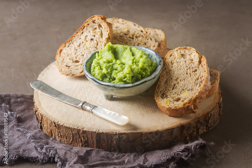 Baguette with mashed green peas and mint. Dark background. Selective focus.