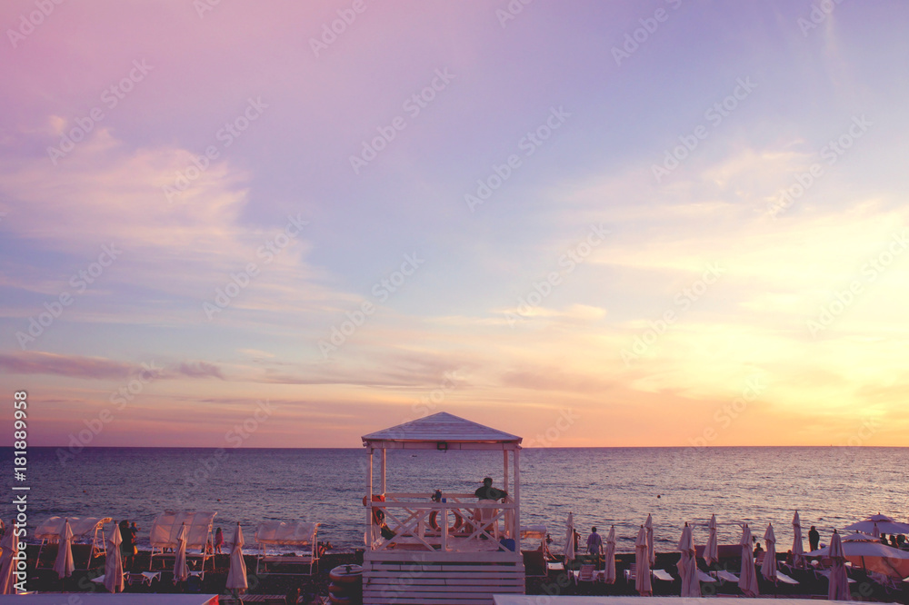 Lifeguard booth at the evening beach. Beautiful evening sea horizon at sunset