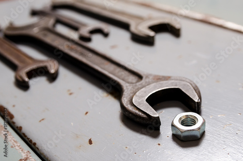 several wrenches and screw-nut on the metal background