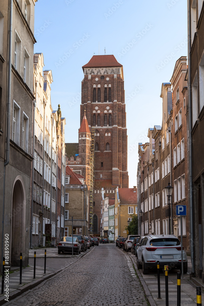 View of old buildings on the Zlotnikow Street and St. Mary's Church at the Main Town (Old Town) in Gdansk, Poland, on a sunny day.