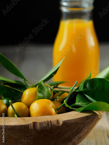 Fresh juice made from kumquats on wooden table. Still life.