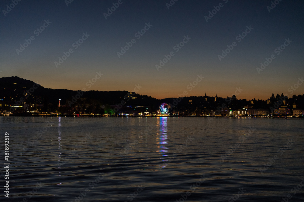 sunset on lake lucerne viewed from boat with city background