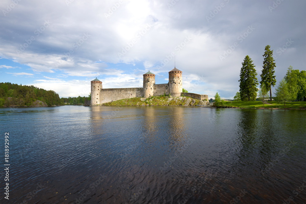 Medieval Olanvinlinna fortress and the Curensalmi strait under a thunder-storming sky. Savonlinna, Finland