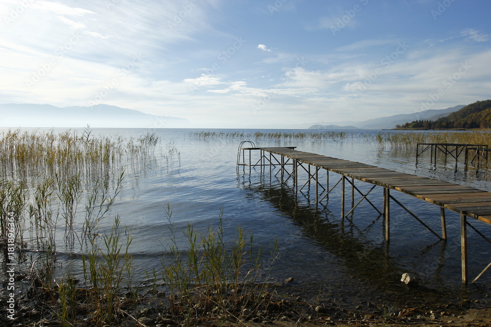 Naklejka premium Old wooden pier by the Ohrid Lake with a cloudy sky on an autumn day