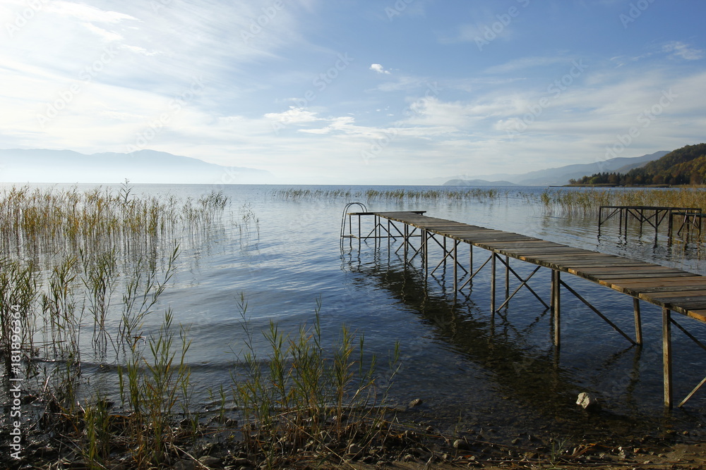 Old wooden pier by the Ohrid Lake with a cloudy sky on an autumn day