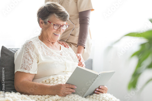 Smiling senior patient reading book