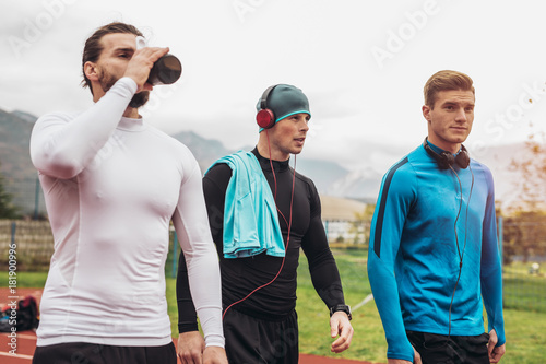 Young athletes practicing a run on athletics stadium track.