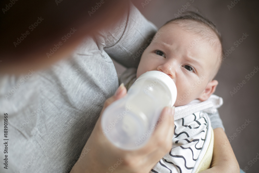Mother holding and feeding newborn baby from bottle. Mother holding and feeding newborn baby from bottle.