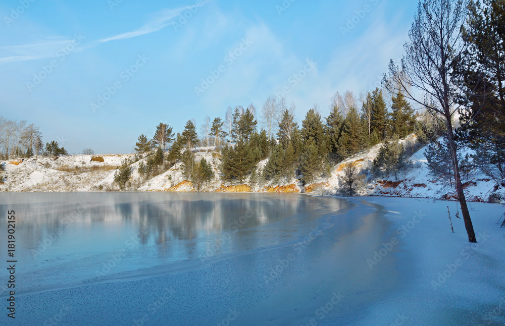 Winter landscape with freezing lake shore in sunny cold day Winter landscape with freezing lake shore in sunny cold day