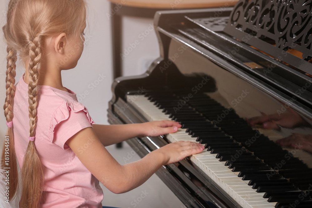 Fototapeta Little girl playing piano indoors