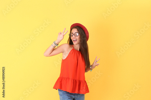 Attractive hipster girl posing on color background