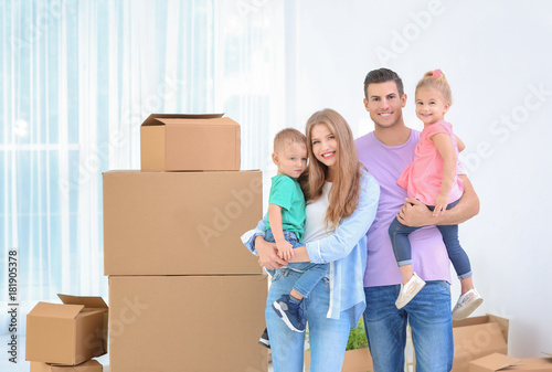 Happy family near moving boxes in their new house © Africa Studio