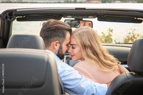 Happy young couple in car o...