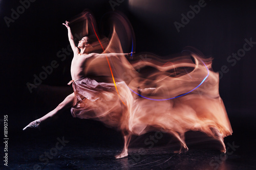 So elegant. Skillful nice flexible woman standing on the floor and showing dance positions while having a rehearsal photo