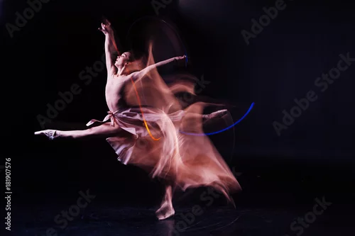 Obraz Cudowne umiejętności. Atrakcyjna miła, zręczna kobieta, wykonująca skok i wykonująca rozszczepienia w powietrzu, pokazując jednocześnie swoją elastyczność