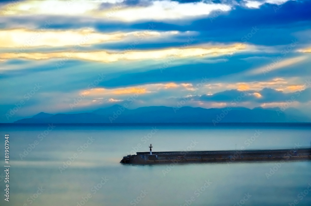 Sunrise in a cloudy sky.Pier in the morning mist at the marina Zeas.Piraeus, Greece