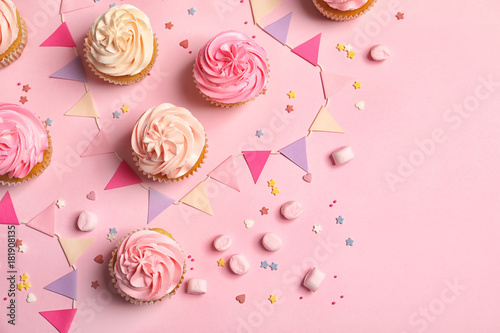Many yummy cupcakes on color background