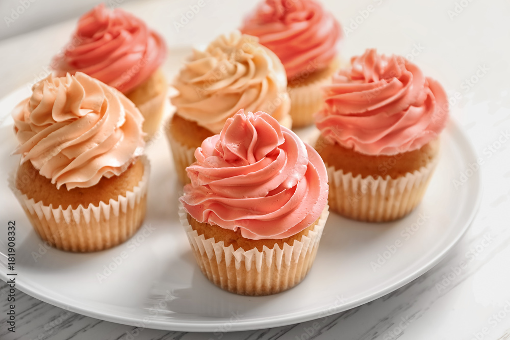 Plate with yummy cupcakes on wooden table Plate with yummy cupcakes on wooden table