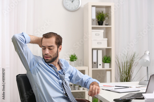 Young man sweating in office
