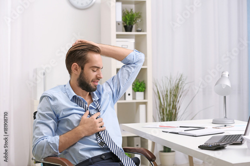 Young man sweating in office