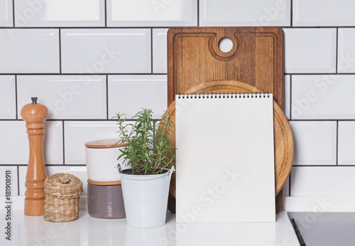 Blank paper mock-up in modern kitchen interior with white tile brick wall and wooden boards photo