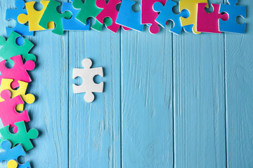 Composition with different puzzles on wooden background. Concept of autism