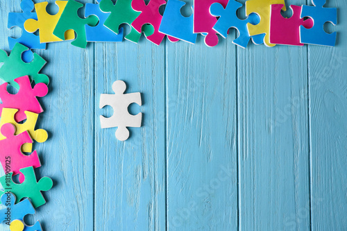 Composition with different puzzles on wooden background. Concept of autism