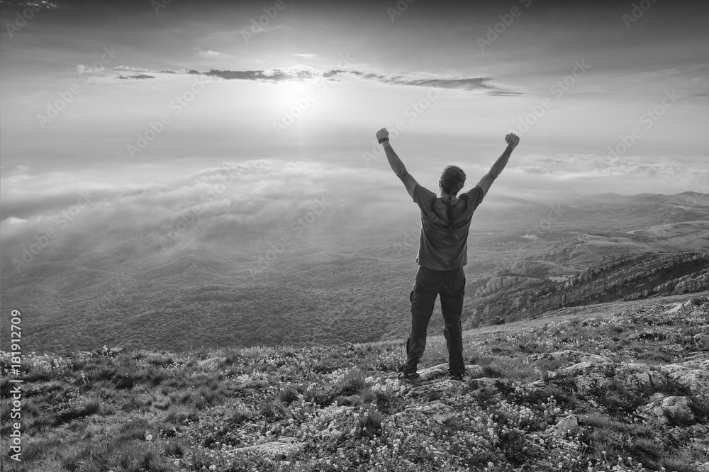 Hiker standing on a hill with raised hands. Black and white Hiker standing on a hill with raised hands. Black and white