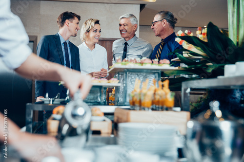 Four Smiling Business People at Buffet Table photo