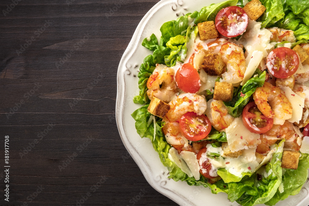 Overhead closeup photo of shrimp Caesar salad with copyspace